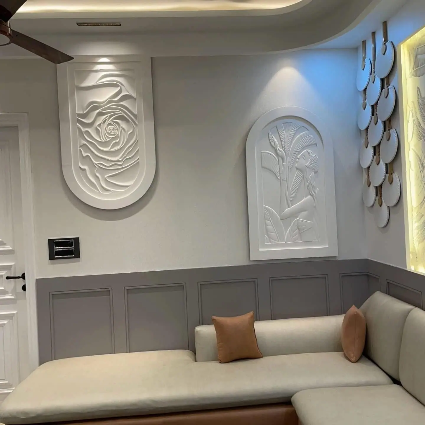 Living room corner with relief-art wall panels, wainscoting and built-in seating